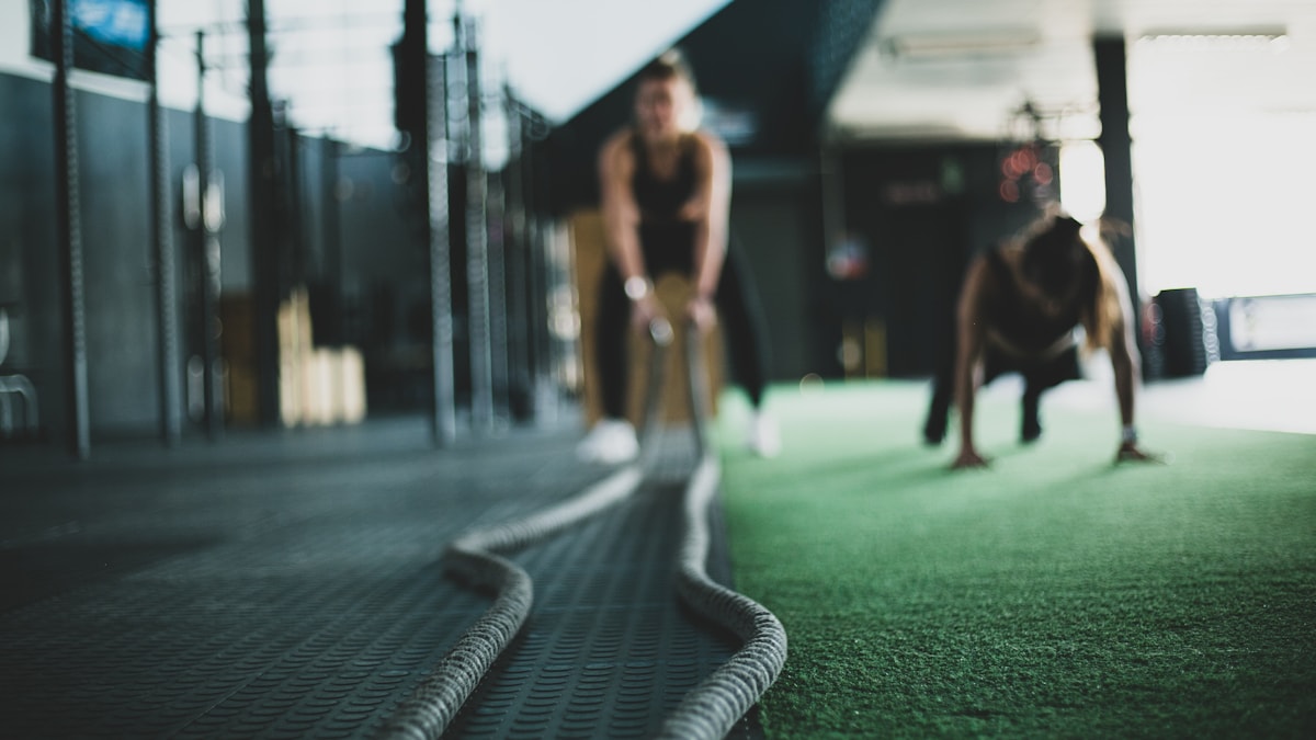 Athlete training with battle ropes in a dark gym